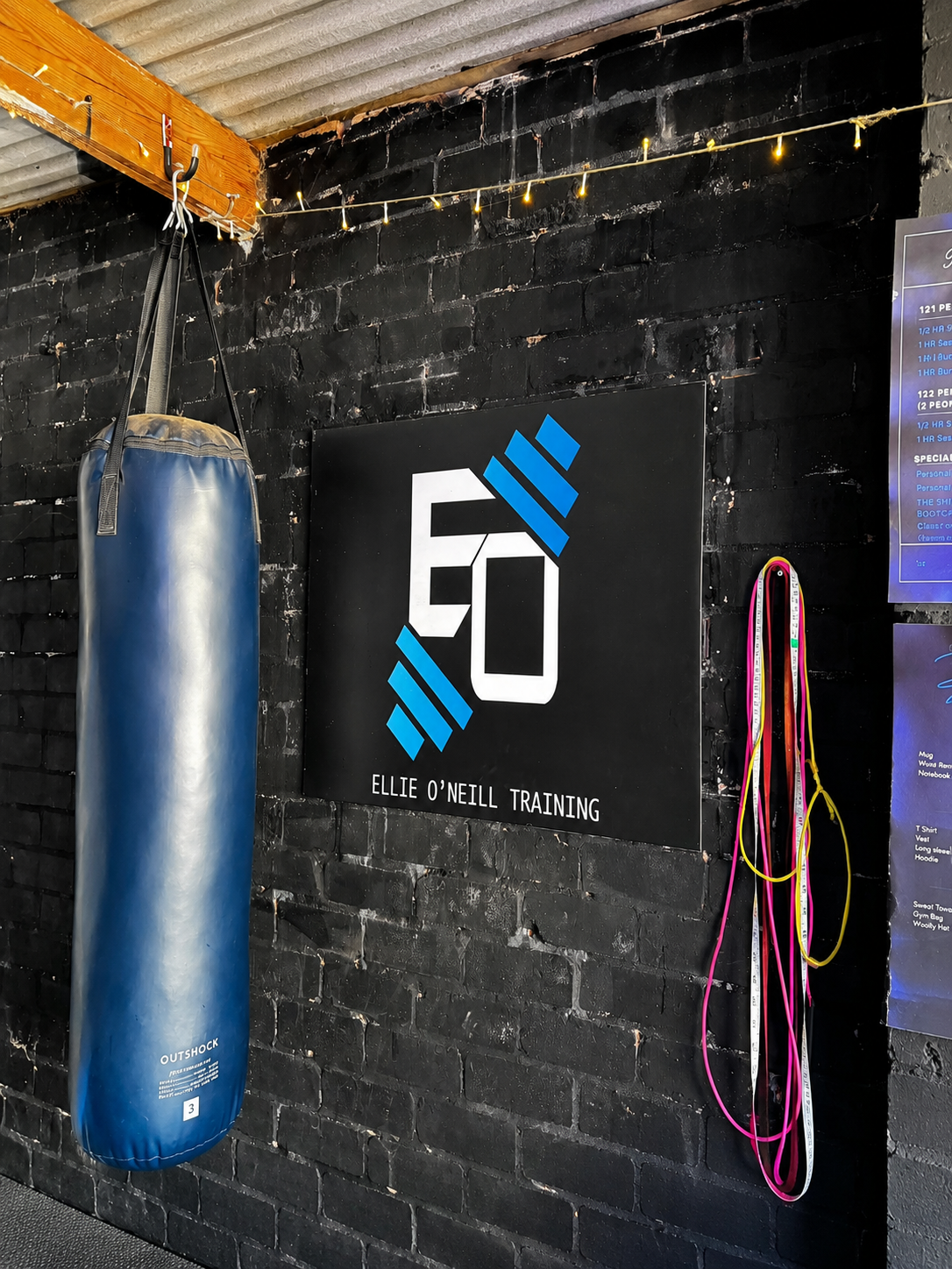 EO Training logo board and punch bag on the black brick wall